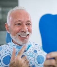 Man with dental implants smiling during dental checkups