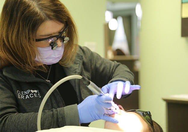 Dental team member examining smile after dental bridge restoration
