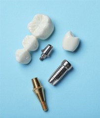 The parts of a dental implant and a bridge on a light blue background