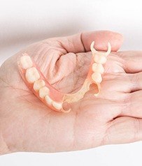 Hand holding partial denture
