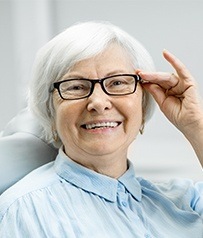 Older woman smiling after dental implant tooth replacement