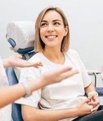Woman talking to dentist about dental insurance coverage for Invsialign
