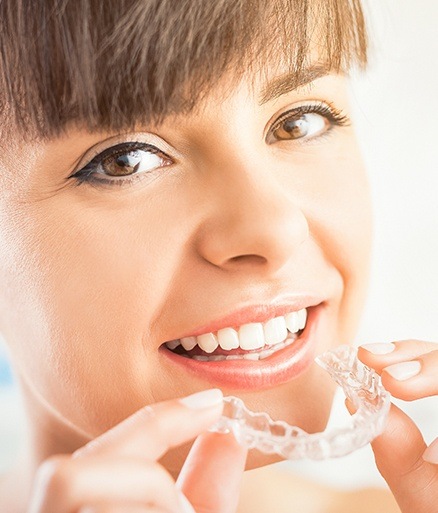 Happy woman positioning her Invisalign tray