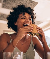 Woman smiling while eating at restaurant