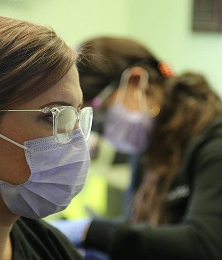 Dental team member examining patient for gum disease