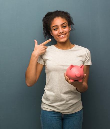 woman with piggy bank pointing to her smile 