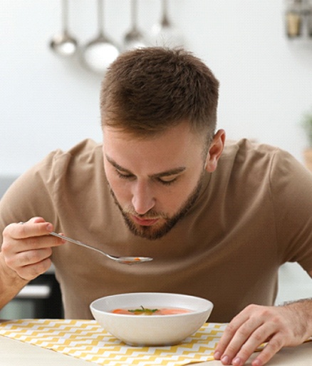 young man eating soup