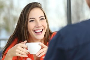 Happy woman with perfect teeth with cup of coffee  