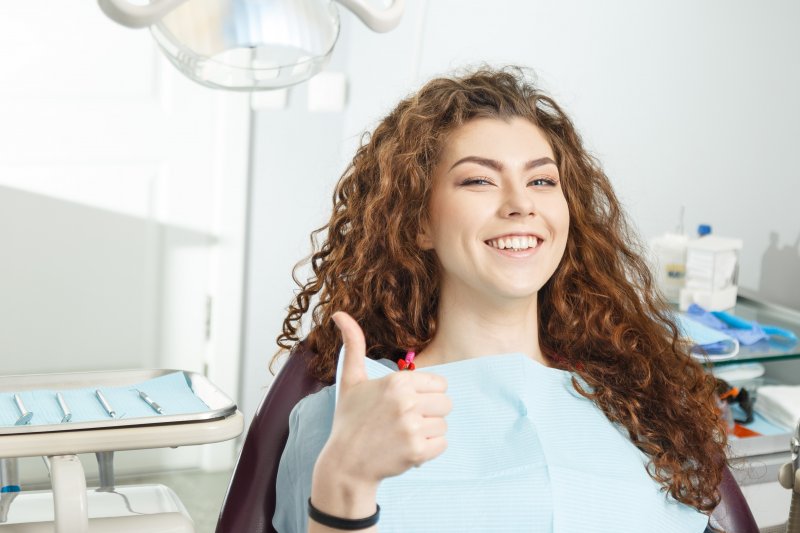 a dental patient giving a thumbs up before a procedure